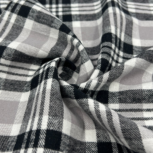 Lightweight cotton flannel shirting fabric featuring a tartan plaid design of black, white & taupe.
