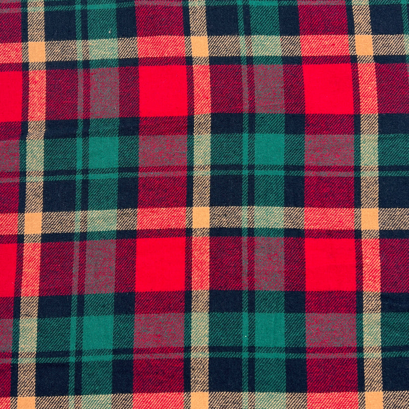 Lightweight flannel shirting fabric featuring a classic woven plaid design using christmas colors of green, red and gold. 