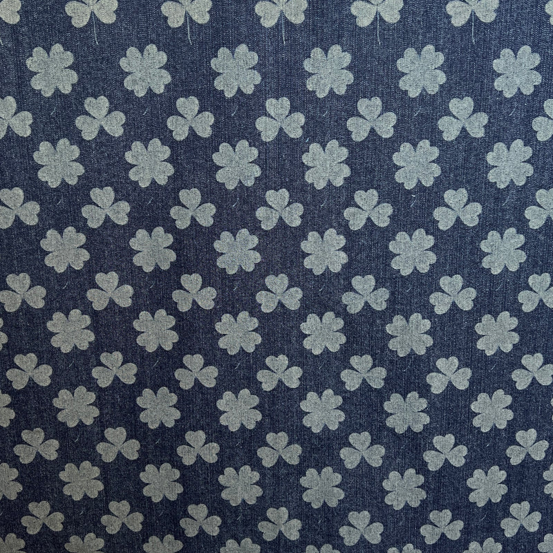 Pattern of clover leaves on a blue fabric background