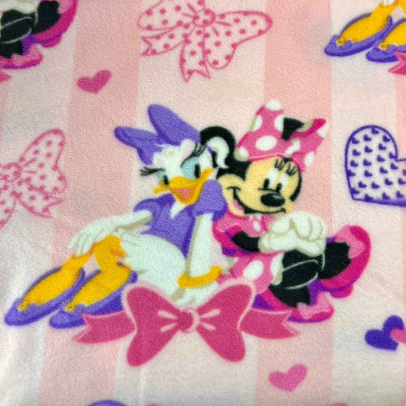Fabric with cartoon characters and colorful patterns on a pink background