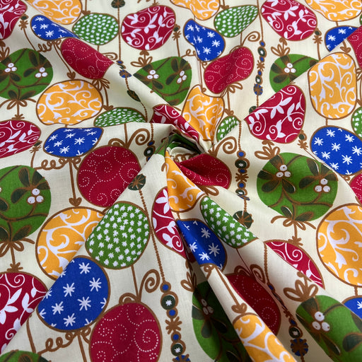 Colorful patterned fabric with various shapes and designs on a beige background