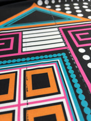 Close-up of a colorful geometric pattern with black, orange, pink, and blue.