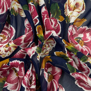 Close-up of floral fabric with pink and green flowers on a dark background