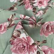 Floral rayon dress weight fabric with pink roses on a green background