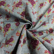 Floral patterned fabric with purple roses on a gray background