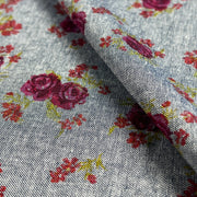 Floral patterned fabric with red roses on a gray background