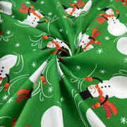Green fabric with snowman pattern on a green background