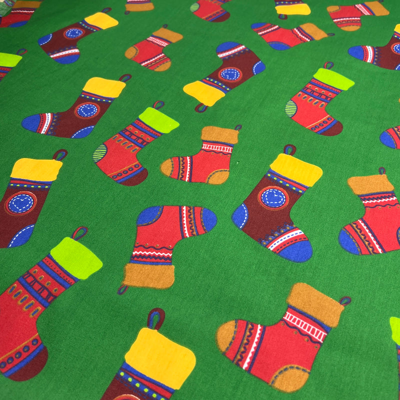 Pattern of colorful Christmas stockings on a green background