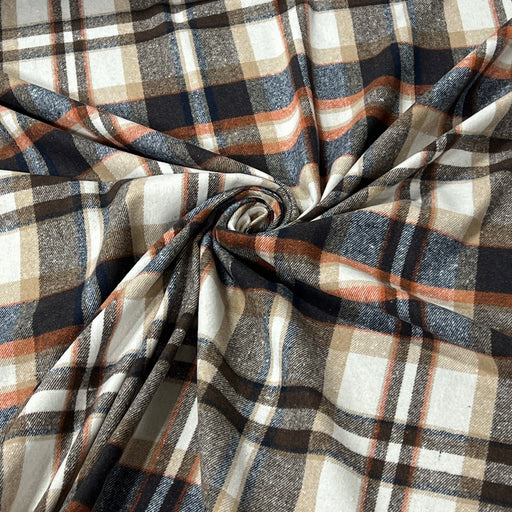 A close-up of draped plaid fabric with a textured weave, featuring intersecting stripes of navy blue, rust orange, beige, and white, arranged in a central spiral.