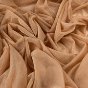A close-up of draped champagne beige sheer fabric with a subtle shimmering texture, arranged in soft folds that fill the entire frame.