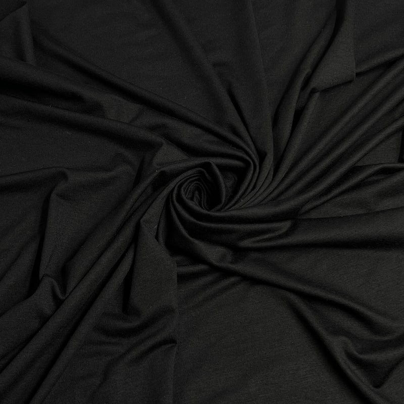 Black fabric draped in a spiral pattern to show its texture and drape.