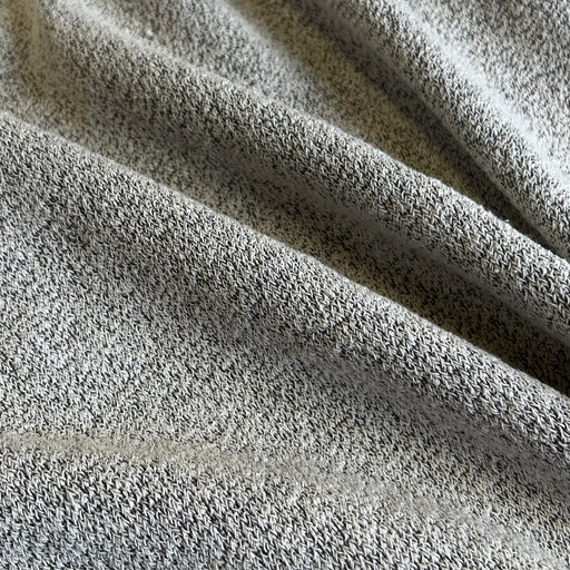 A close-up of a heather gray terry cloth fabric, showing its soft, textured loop pile and draped folds.