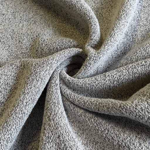 A close-up of a heathered gray knit fabric, draped in soft folds to show its texture and weave.