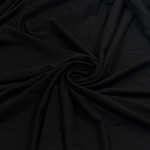 Black soft rayon and lycra jersey pulled into a swirl showing off smooth drape and texture. 