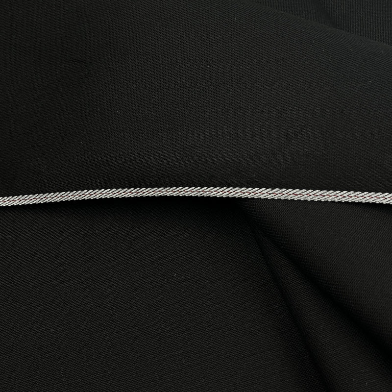 A close-up of black fabric with a thin, braided silver cord or trim running horizontally across the center.