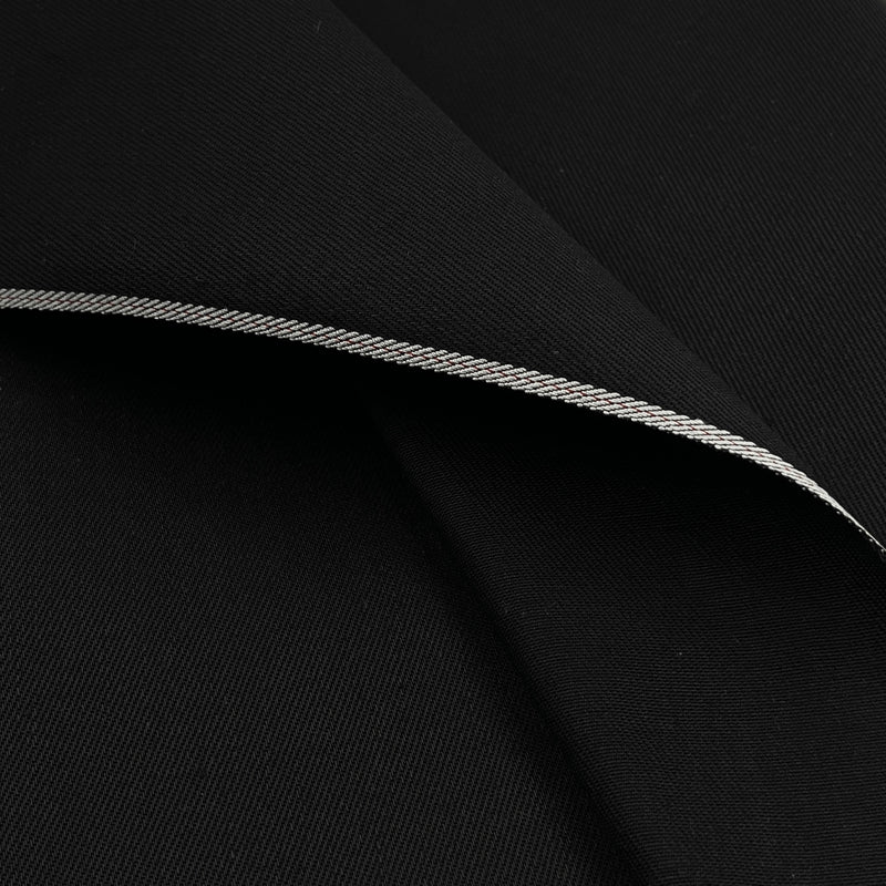 A close-up of black fabric with a folded edge showing a thin silver-gray stitched trim.