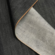 Close up of edge of selvedge denim contrasting the face against the reverse of the fabric