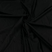 Black fabric draped in a spiral pattern, showing its smooth texture and soft folds.