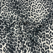 Black and white leopard print fabric draped in a spiral pattern to show its texture and drape.
