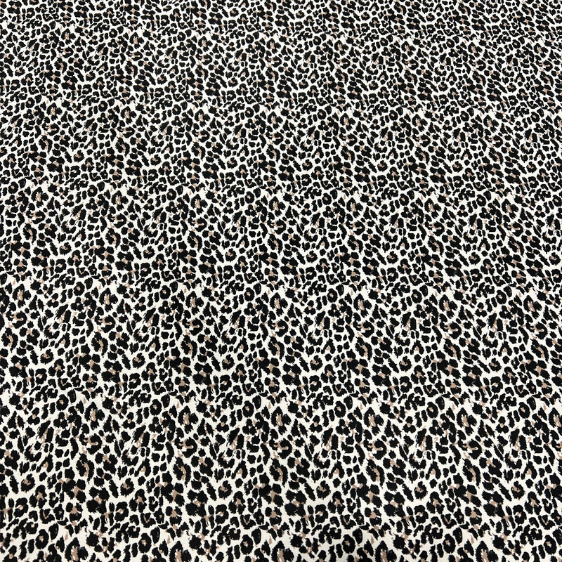 A close-up of a black and off-white leopard print fabric pattern filling the entire frame.