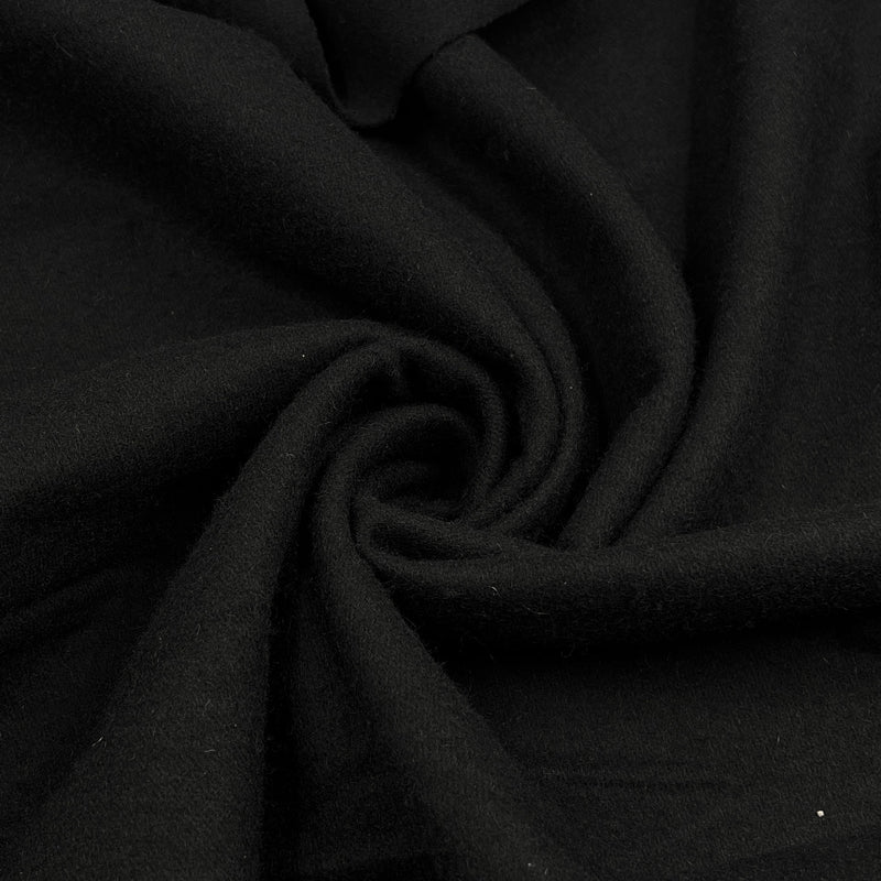 A close-up of draped black wool fabric arranged in a spiral, showing the material's texture and soft folds.