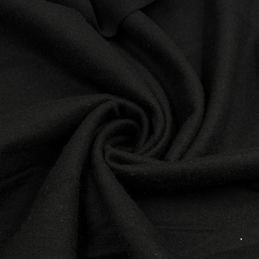 A close-up of draped black wool fabric arranged in a spiral, showing the material's texture and soft folds.