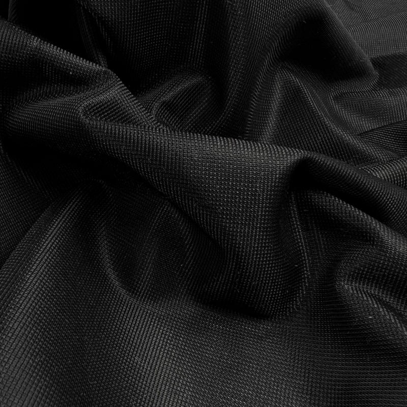 A close-up of draped black fabric with a fine textured weave, showing soft folds and shadows.