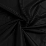 A close-up of draped black fabric with a subtle sheen, arranged in soft folds and swirls.