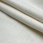 A close-up of folded off-white woven fabric with a visible textured weave and soft shadows in the creases.
