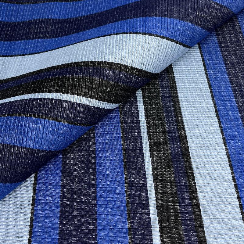 A close-up of a corded upholstery fabric with a striped pattern in shades of blue, navy, black, and light blue.