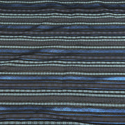 A close-up of a patterned fabric with horizontal stripes in shades of blue, black, and light gray, featuring geometric and tribal-inspired woven motifs.