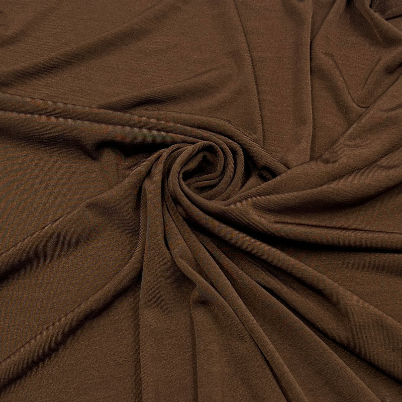 A close-up of draped brown fabric arranged in a spiral twist, showing the material's texture and color.