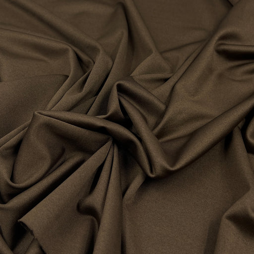 A close-up of draped dark brown fabric with soft folds and a smooth texture.