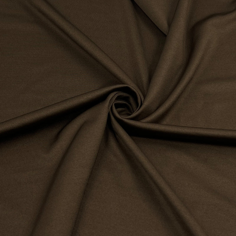 A close-up of draped dark brown fabric arranged in a spiral, showing the material's smooth texture and soft folds.
