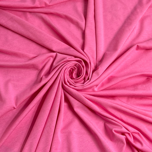 Bright pink fabric draped in a spiral pattern, showing its soft texture and drape.