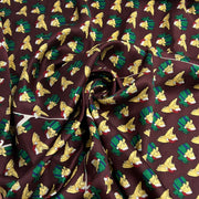 A closeup of 100% silk printed with puppy dogs resting on Christmas presents, wearing Santa hats over a burgundy background. 
