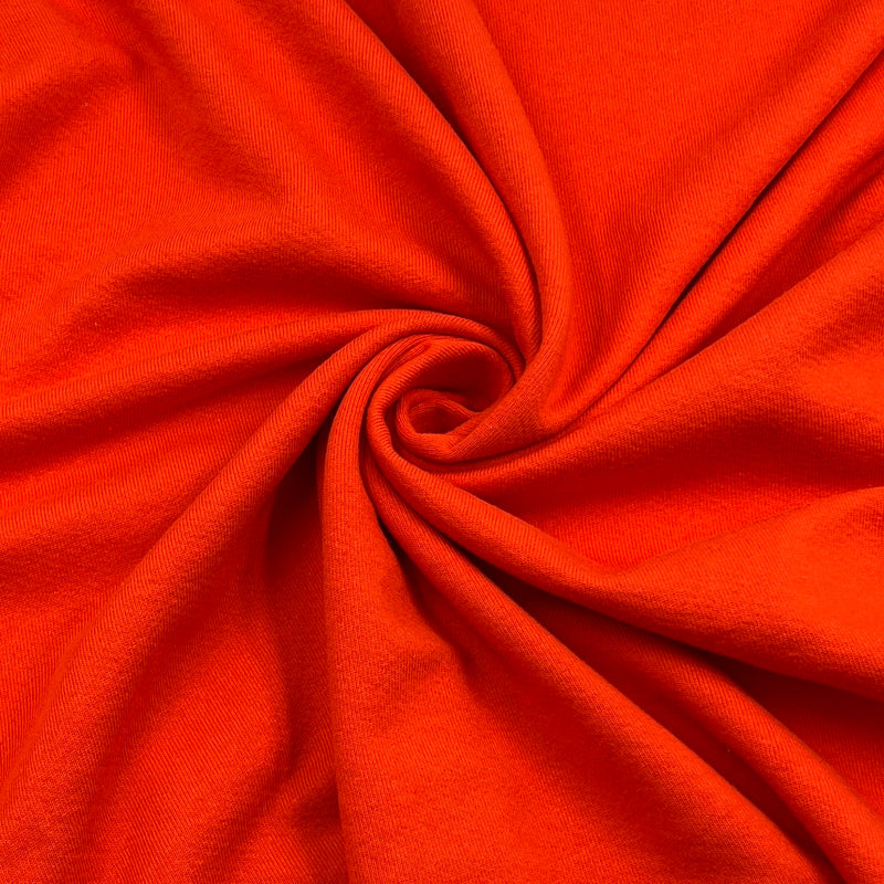 Bright orange-red fabric draped in a spiral pattern, showing a smooth woven texture.
