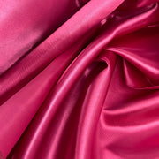 Medium weight bridal satin in a red-toned hot pink color with a moderate drape and structured hand draped to show off texture. 