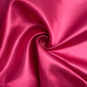 Candy pink bridal satin pulled into a swirl to show off fluid drape and structured hand. 