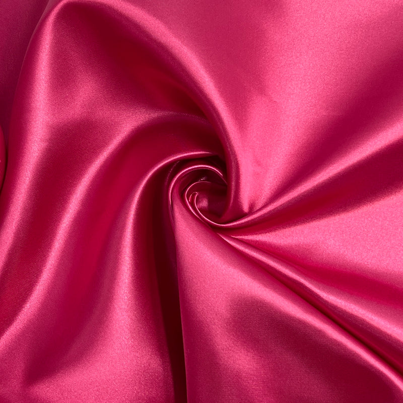 Candy pink bridal satin pulled into a swirl to show off fluid drape and structured hand. 