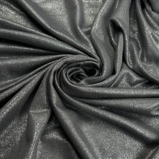 A close-up of draped metallic fabric in a dark charcoal gray color with a subtle shimmering finish, arranged in a spiral pattern.