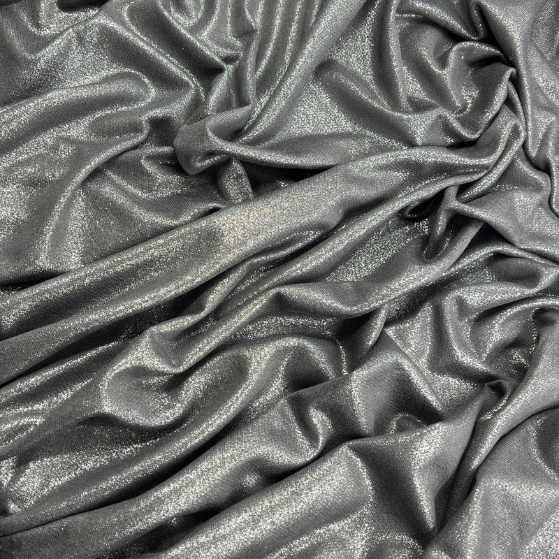 A close-up of draped metallic gray fabric with a subtle shimmer and soft folds filling the frame.