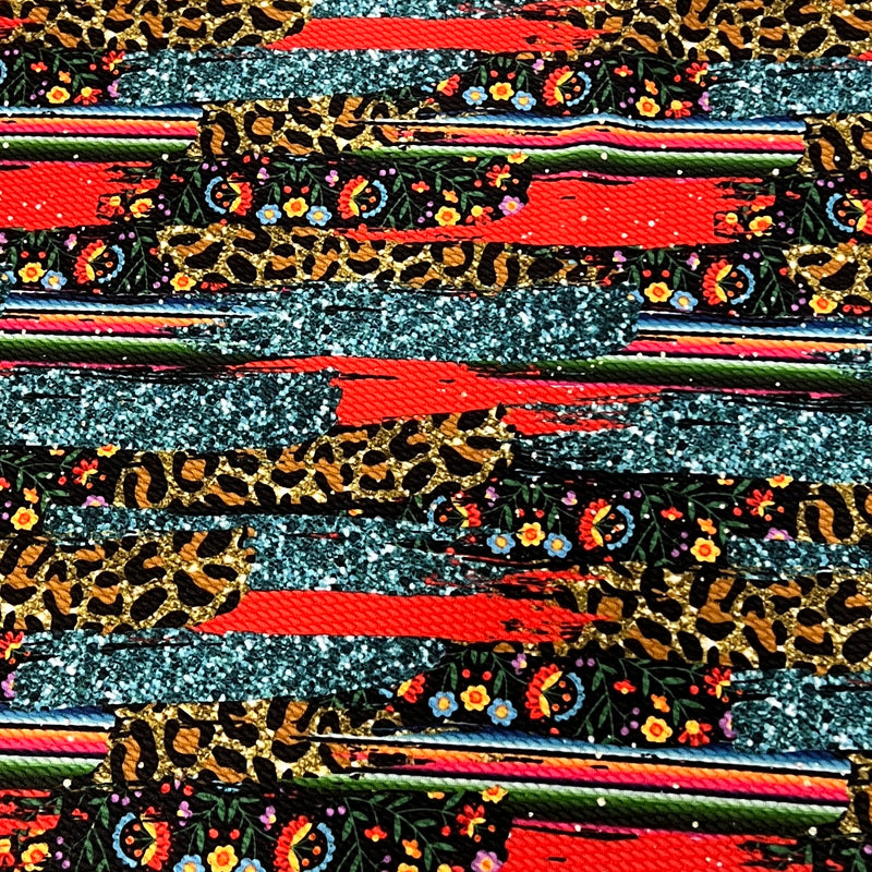 A close-up of a highly textured fabric featuring a complex multicolor pattern with leopard print, glittery silver stripes, red brushstrokes, and small floral motifs.