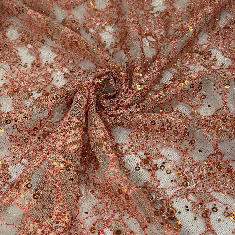 Rose gold sequin lace fabric draped in a spiral pattern, showing intricate floral lace details covered in shimmering rose gold sequins and glitter.
