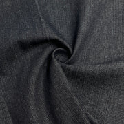 Closeup of dark indigo broken twill denim pulled into a swirl. 