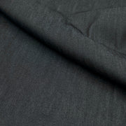 A close-up of dark charcoal gray textured fabric with a diagonal fold showing the material's fine weave.