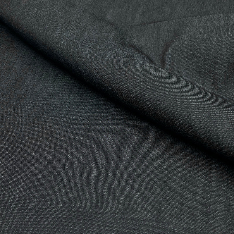 A close-up of dark charcoal gray textured fabric with a diagonal fold showing the material's fine weave.