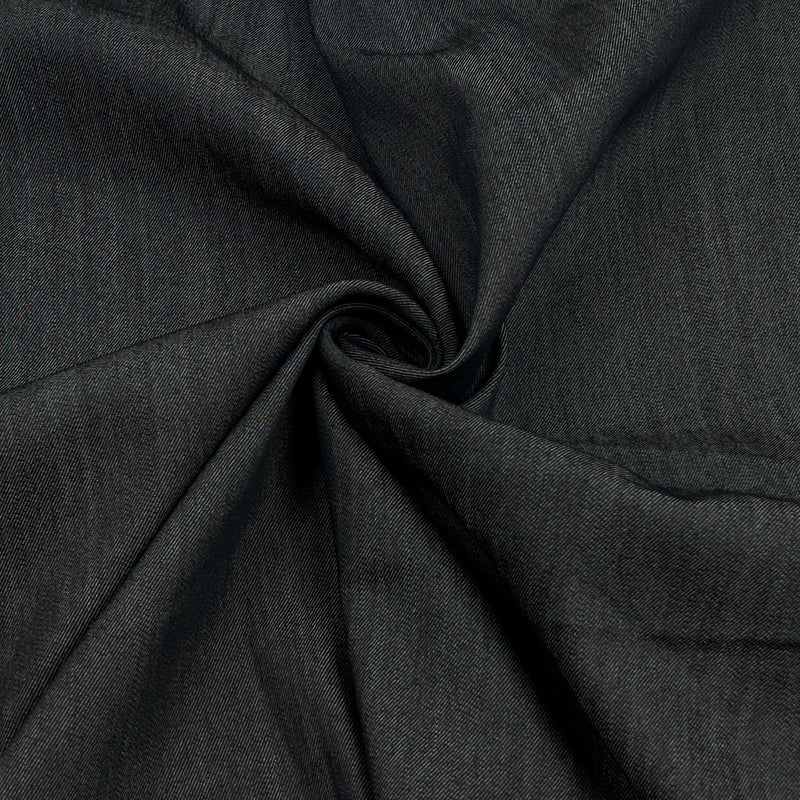 A close-up of dark charcoal gray fabric with a textured weave, arranged in a spiral drape to show its texture and flexibility.