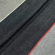 A close-up of a woven textile with a dark charcoal gray body, light gray side panels, and a thin red accent line.