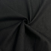 A close-up of draped black fabric with a textured weave, gathered in the center to show its drape and fine knit pattern.
